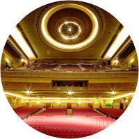 Un gran auditorio con asientos rojos y un techo circular.