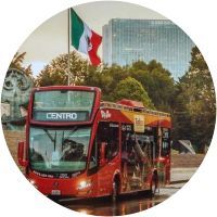 Un autobús rojo de dos pisos circula por una calle en círculo.