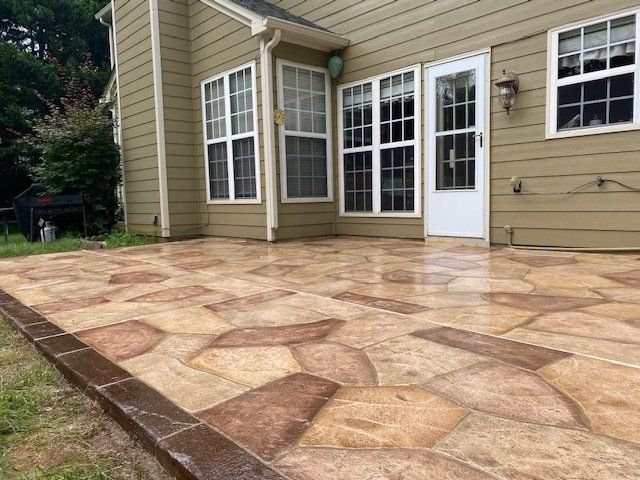 Stone patio beside beige house with white French doors and windows