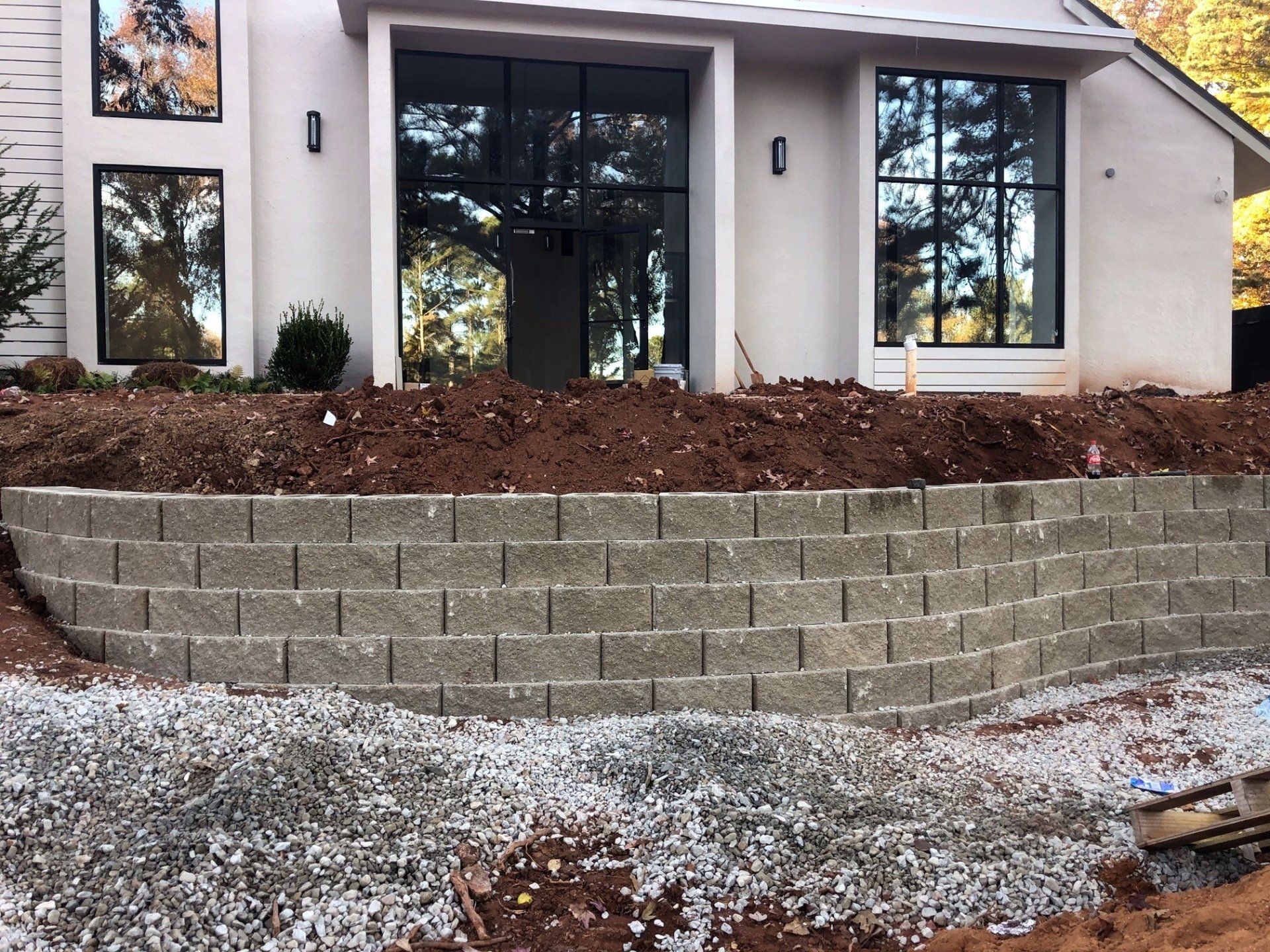 Modern house exterior with a new stone retaining wall and landscaped front yard