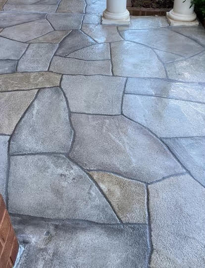 Stone patio with irregular gray flagstones and a white column in the background