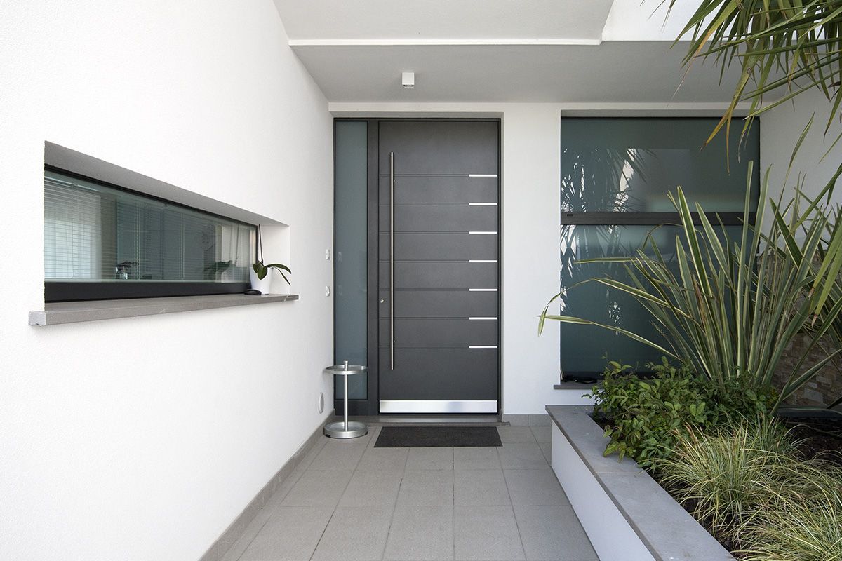 Una casa moderna con una porta nera e una finestra