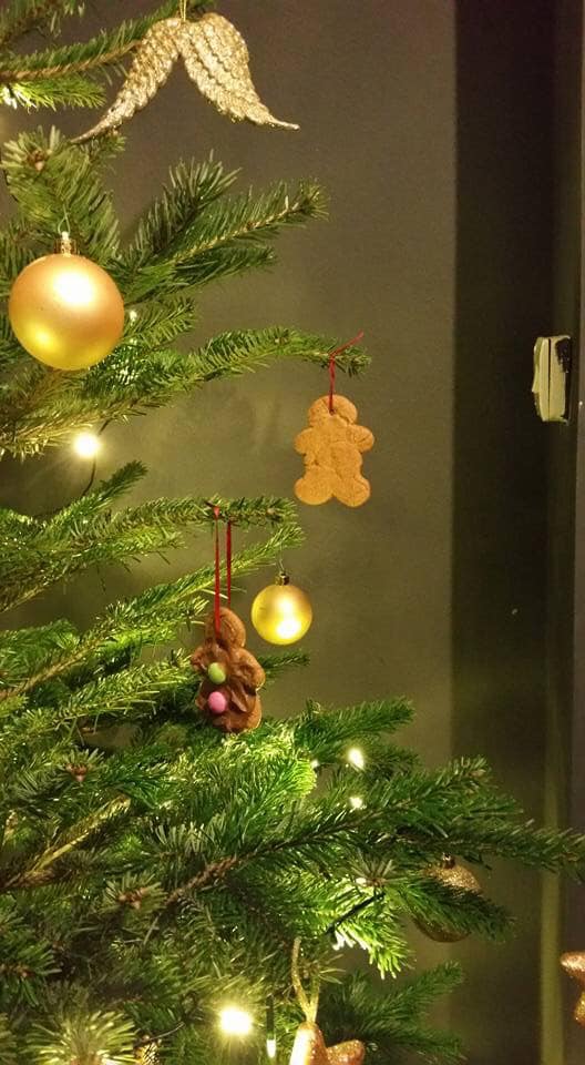 Christmas tree with gold ornaments and gingerbread man decorations.