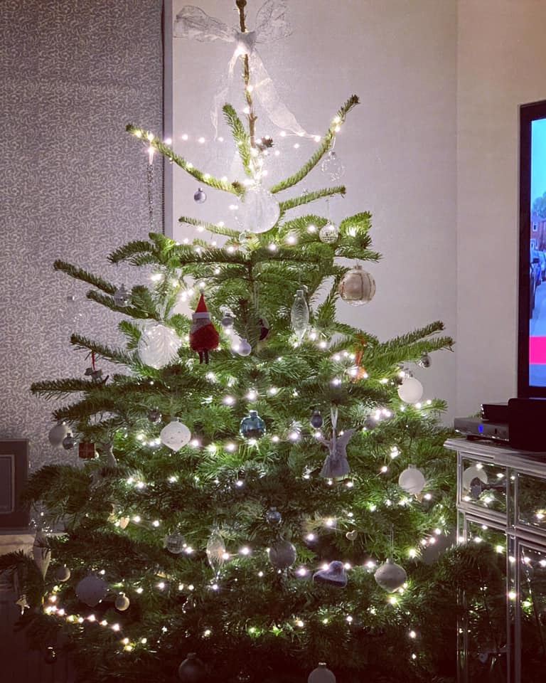 Christmas tree with white lights and ornaments indoors.
