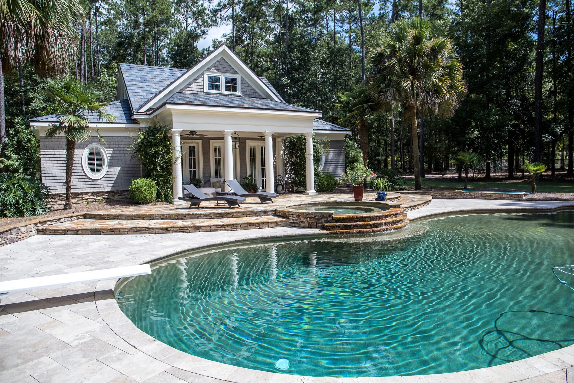 A custom, large pool behind a landscaped estate.