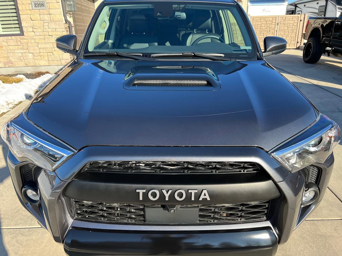 Front view of a black Toyota SUV parked outdoors, showing the grille and hood.