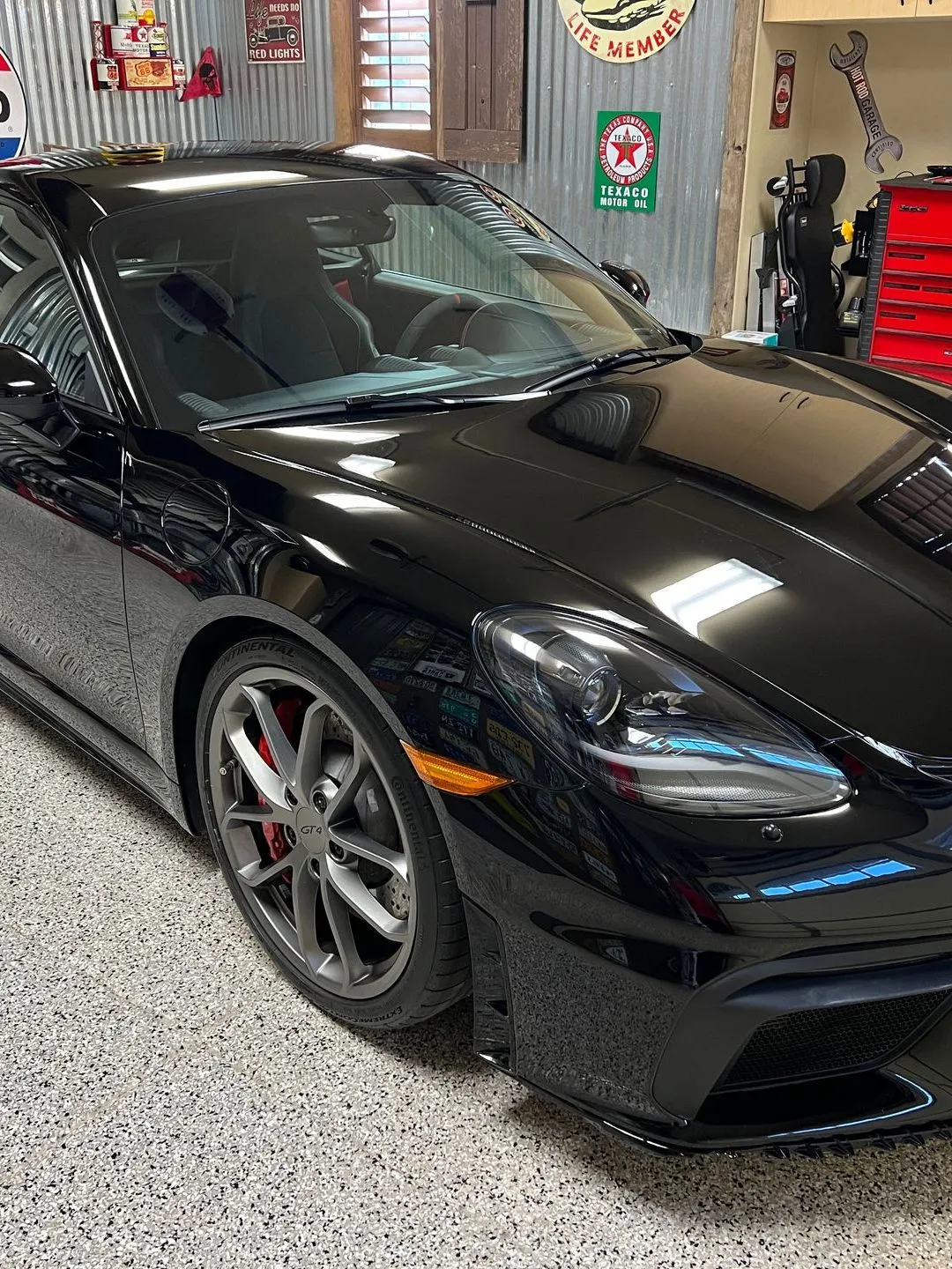 Black sports car parked in a garage with a decorative interior.