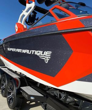 A super air nautique boat is parked on a trailer