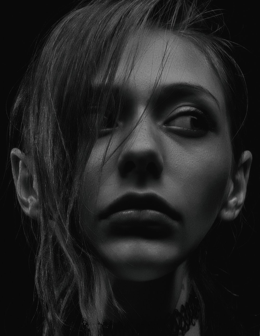 A close up of a woman 's face in a black and white photo.