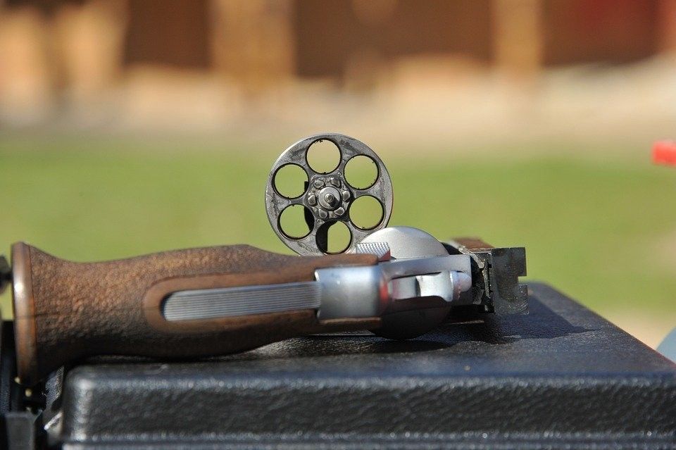 A revolver is laying on top of a black case.