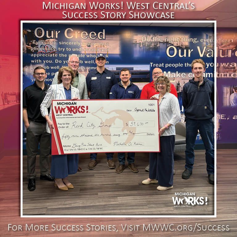 Group holding a large check at Michigan Works! West Central success story showcase backdrop