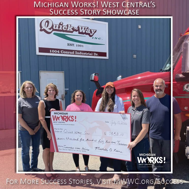 Award presentation outside Quick-Way; group holds oversized check beside a red truck.