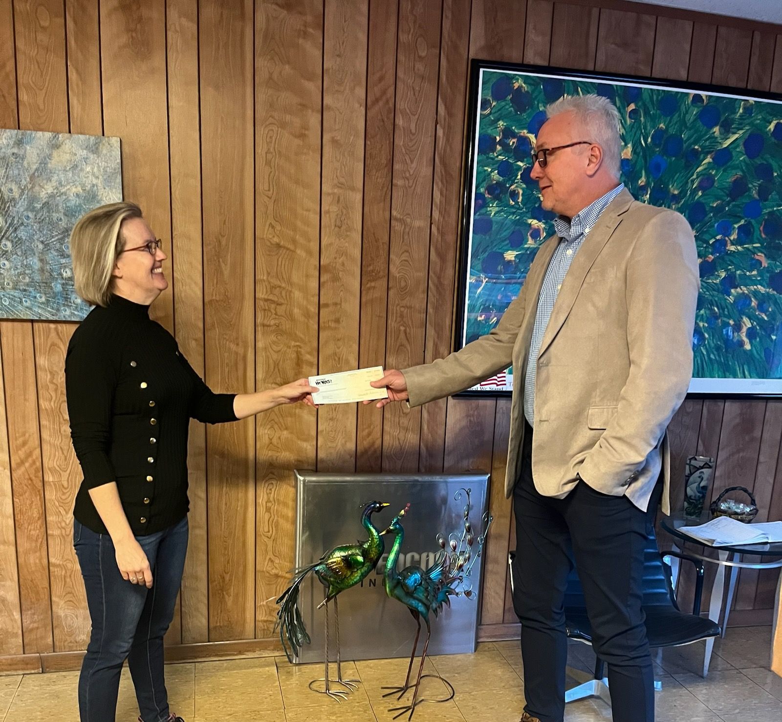 Debra Plaster, the human resource director of Peacock Industries in Lake County (left), accepts a reimbursement check from Kevin Welch, Business Services Specialist for Michigan Works! West Central. Peacock Industries completed training for 7 individuals through the annual Going PRO Talent Fund grant program.
