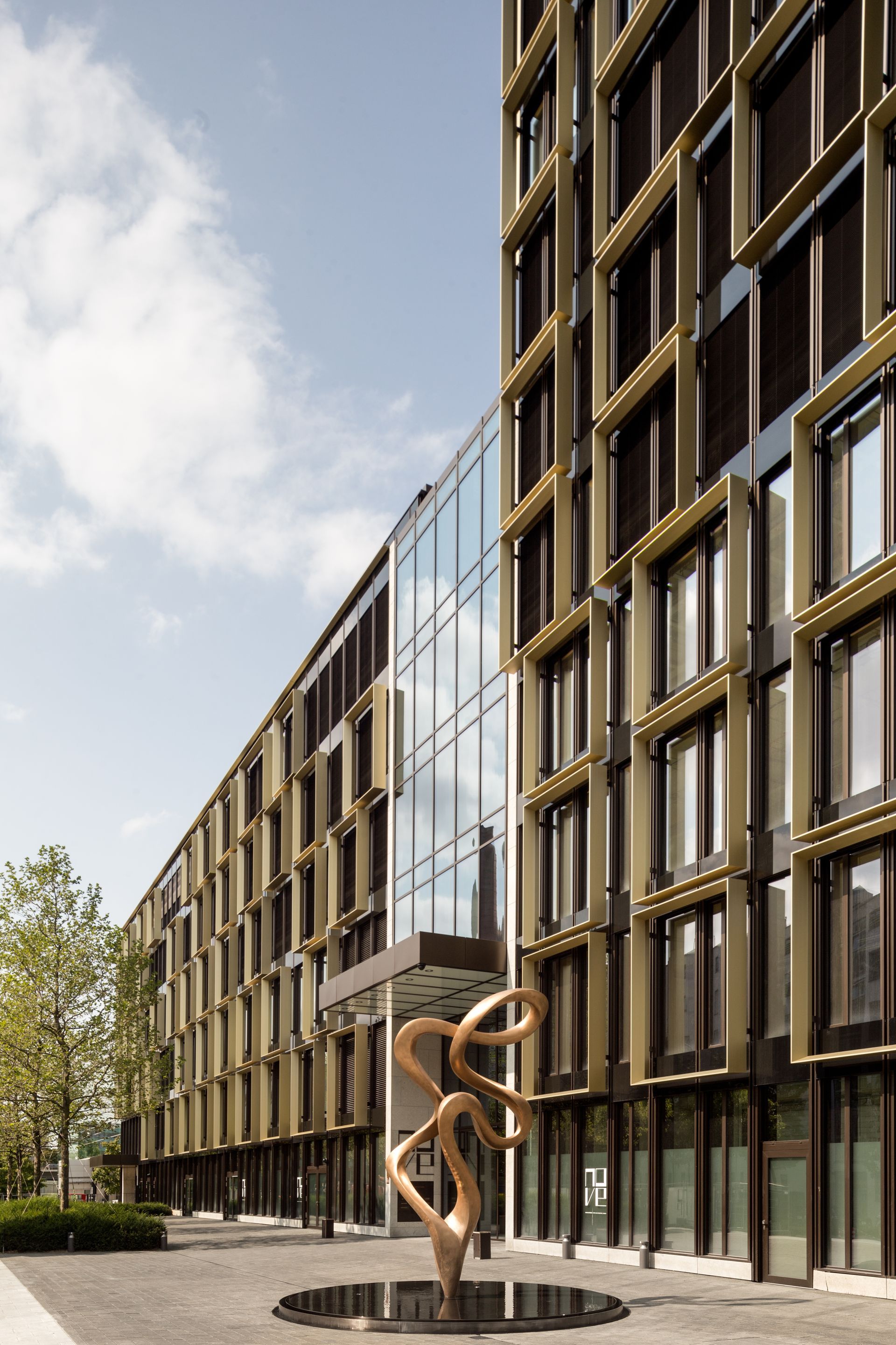 Ein großes Gebäude mit einer Skulptur davor.