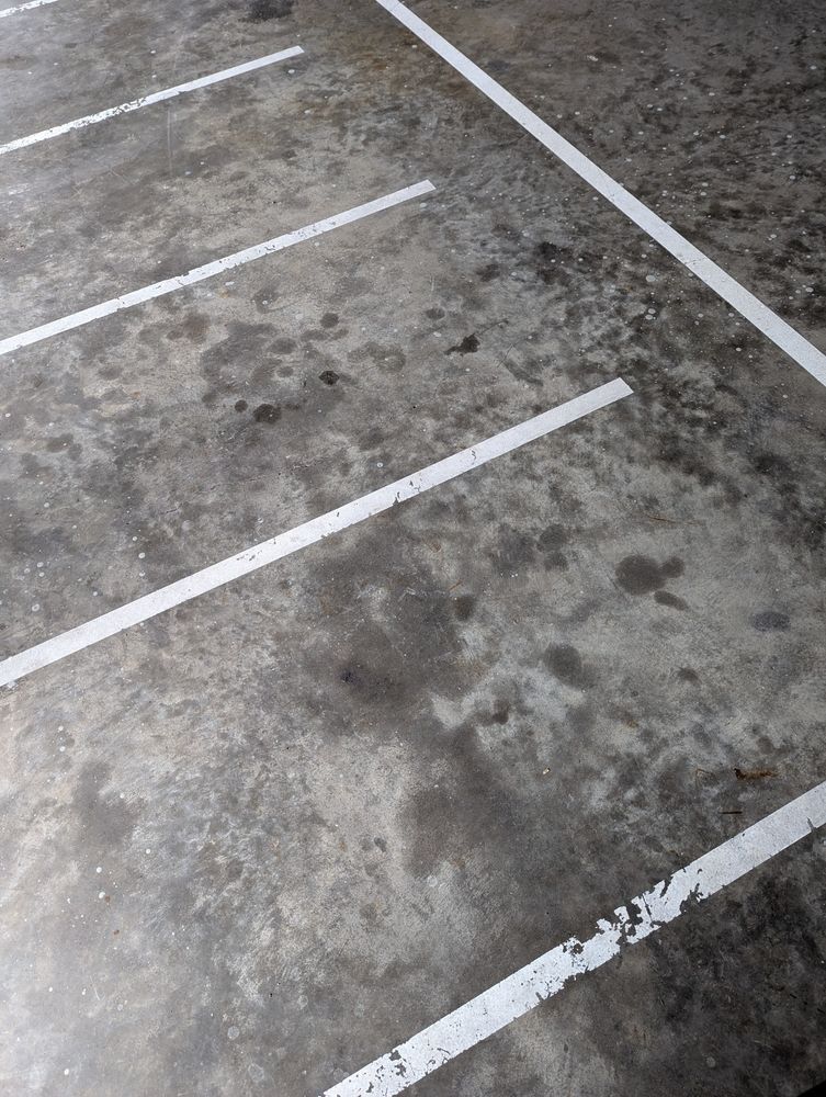 Concrete parking lot surface with marked parking stalls shown from above.