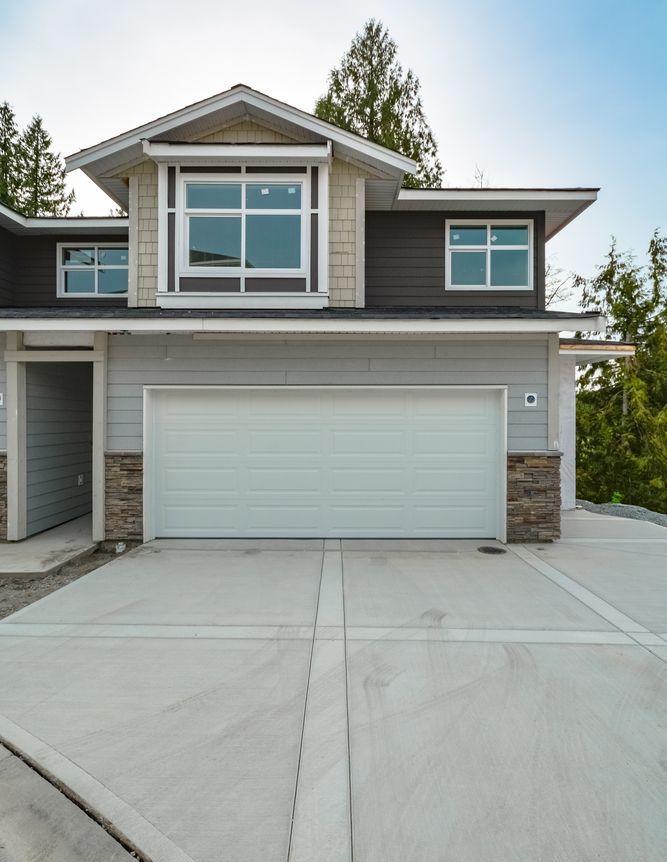 New concrete driveway in front of a modern home with a two-car garage.