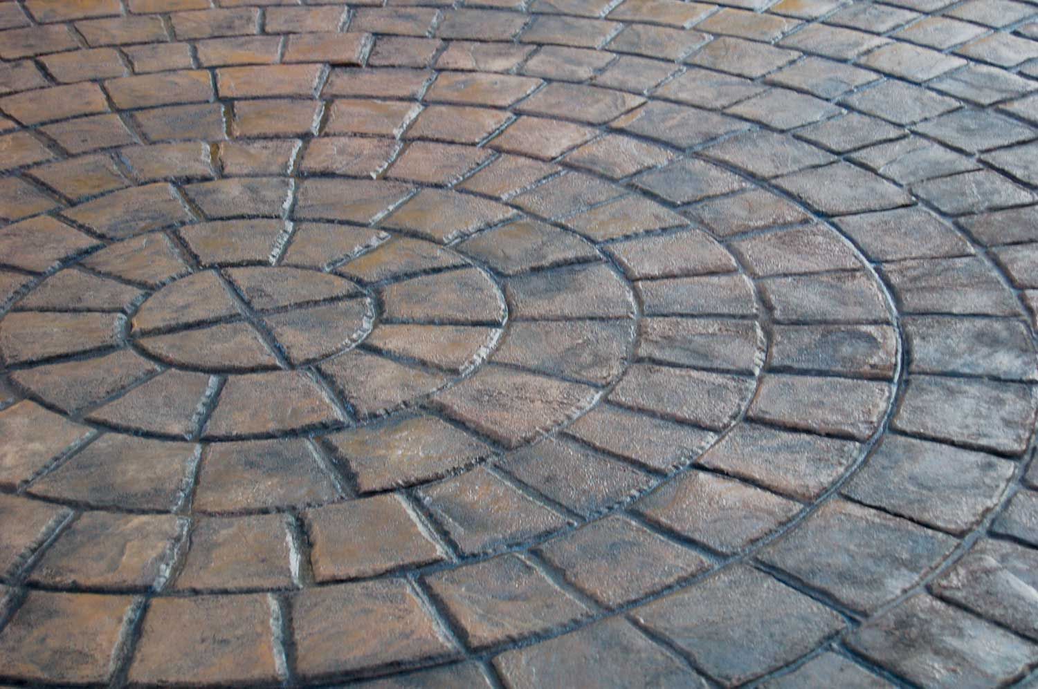 Cobblestone Circle & Fan stamped concrete with curved brick patterns and textured finish.