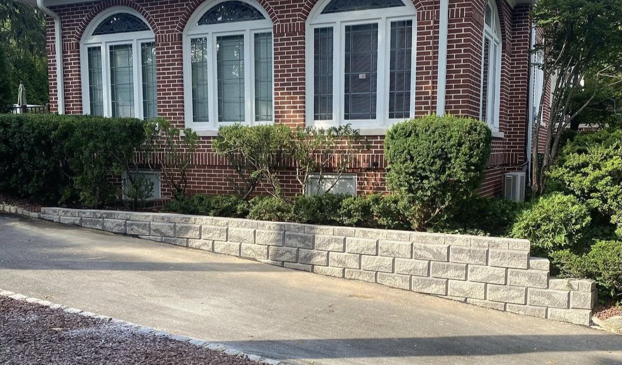 Brick house with a retaining wall and driveway.
