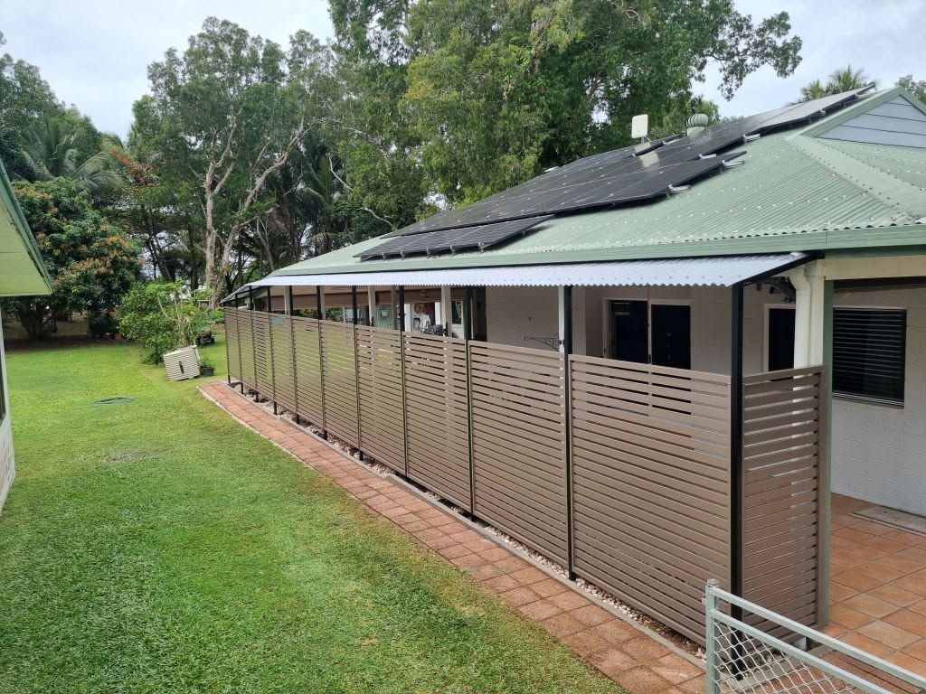 Covered Outdoor Walkway Beside a Beige Building — A & B Lattice World & Patios In Douglas Shire, QLD