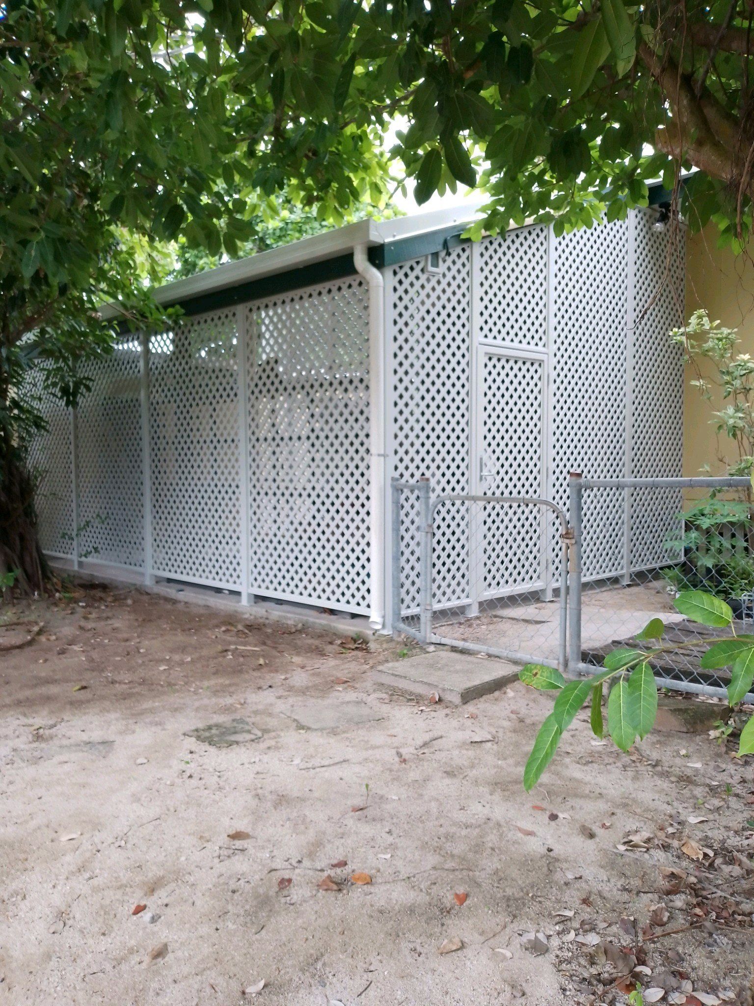 A Wooden Lattice Wall with A Door in A Room — A & B Lattice World & Patios in Bungalow, QLD