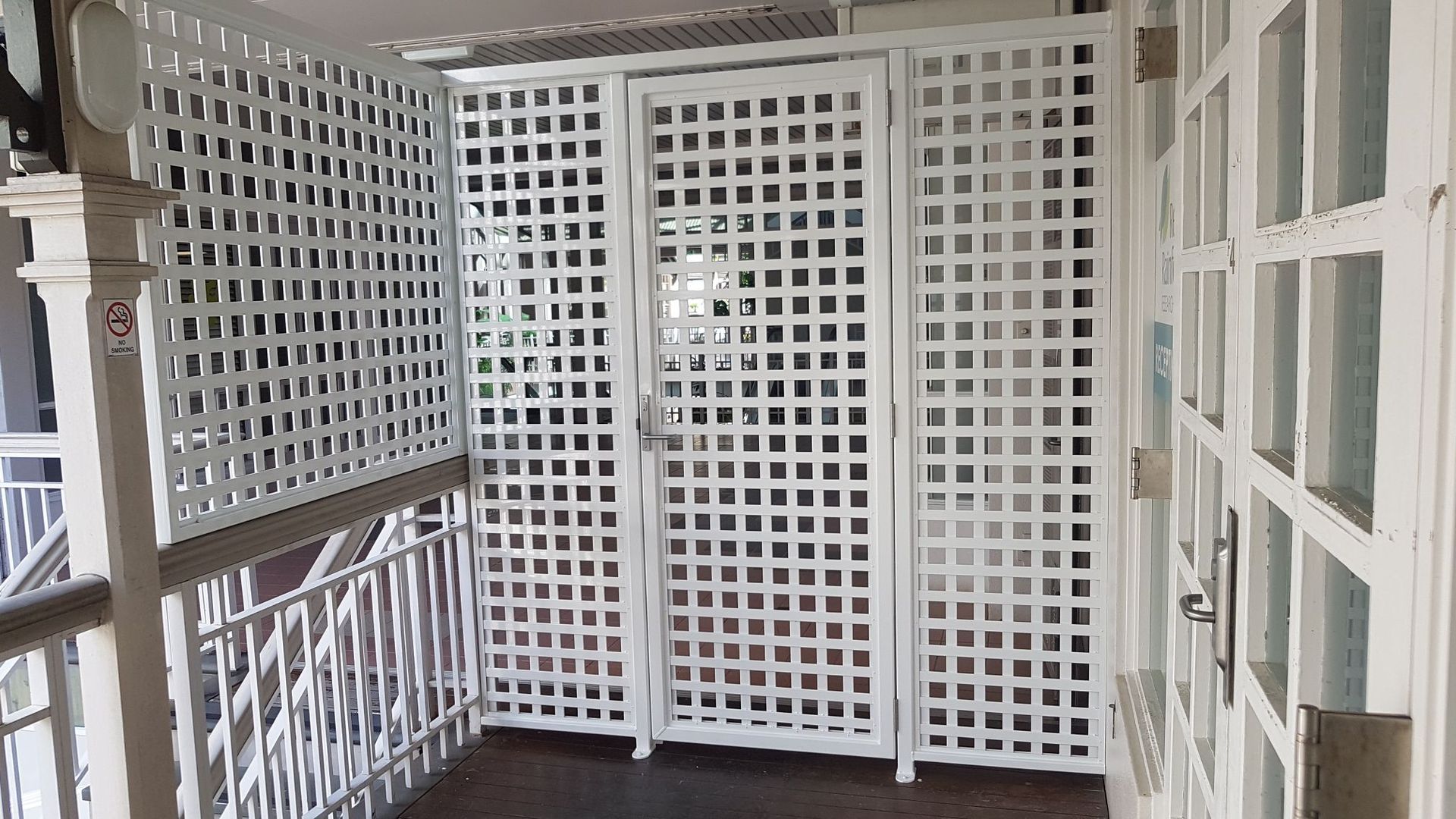 A Wooden Lattice Fence with A Door in A Warehouse — A & B Lattice World & Patios in Bungalow, QLD
