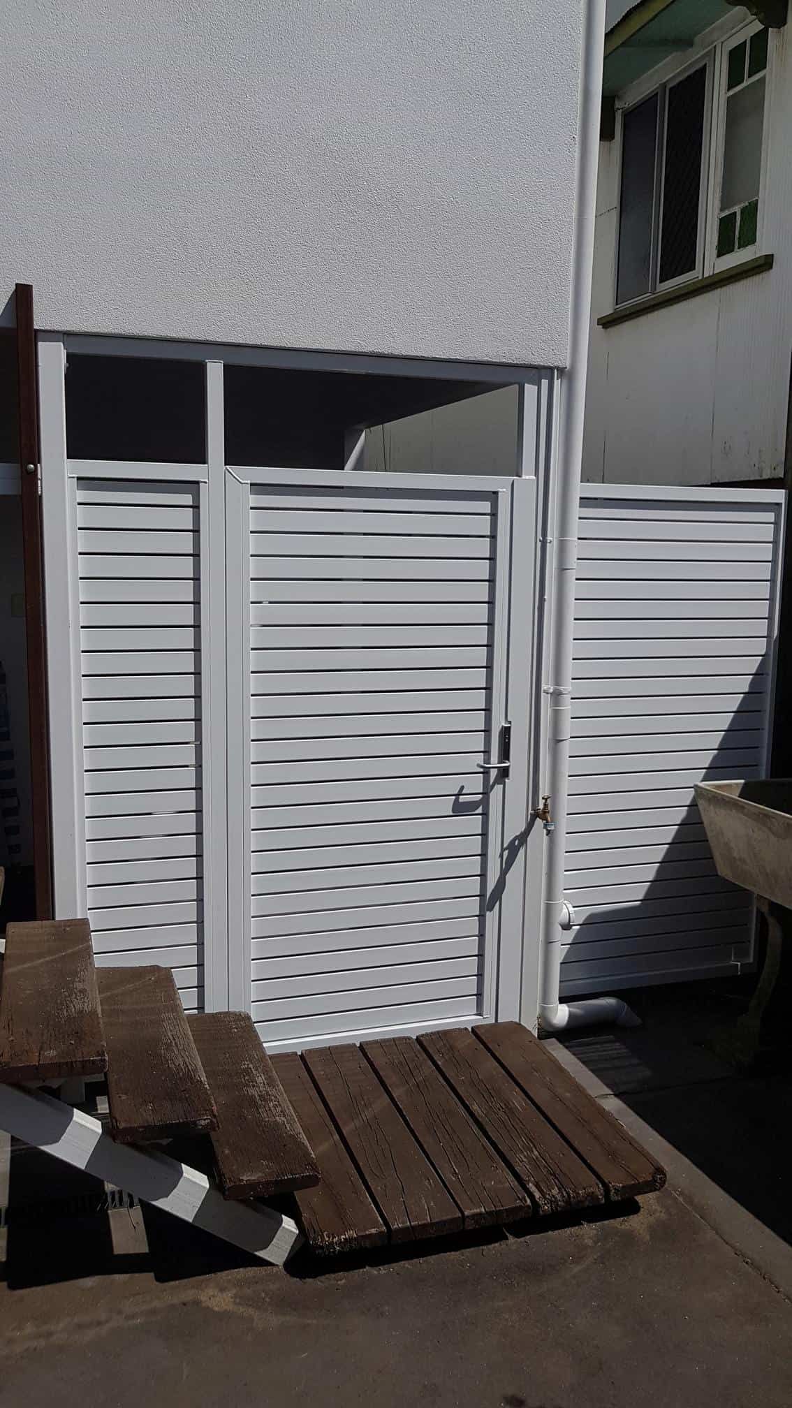 A White Gate With a Wooden Bench in Front of It — A & B Lattice World & Patios In Tablelands, QLD