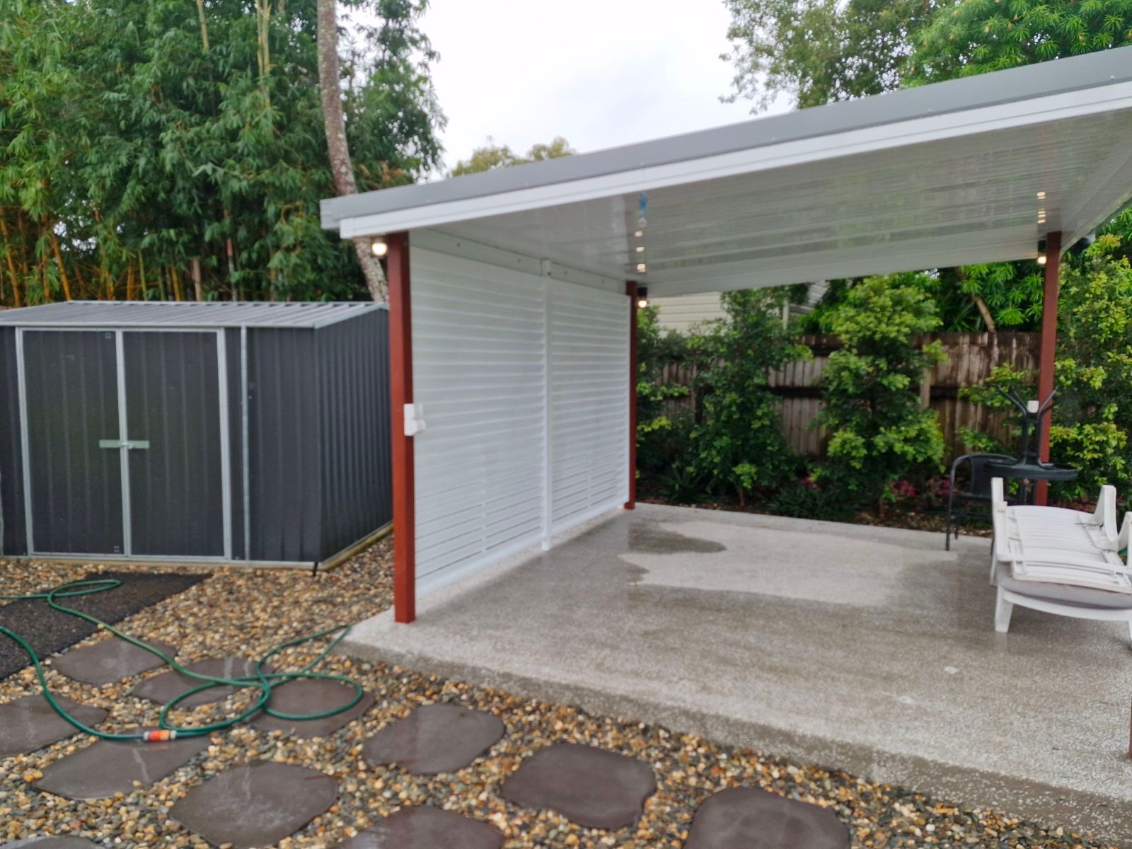 A White Lattice Box Is Sitting in Front of A Brick Building — A & B Lattice World & Patios in Bungalow, QLD