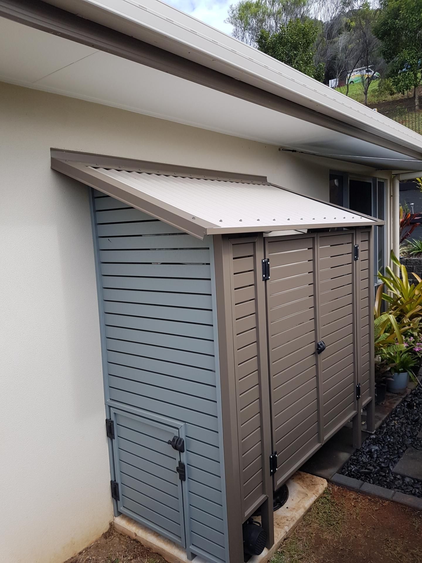 A House with A Metal Siding and A Garage with The Door Open — A & B Lattice World & Patios in Bungalow, QLD