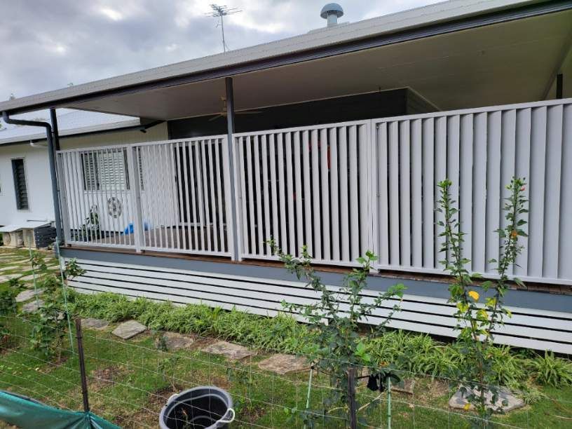 A Living Room with A Couch, Chair, Table and A Large Window — A & B Lattice World & Patios in Bungalow, QLD