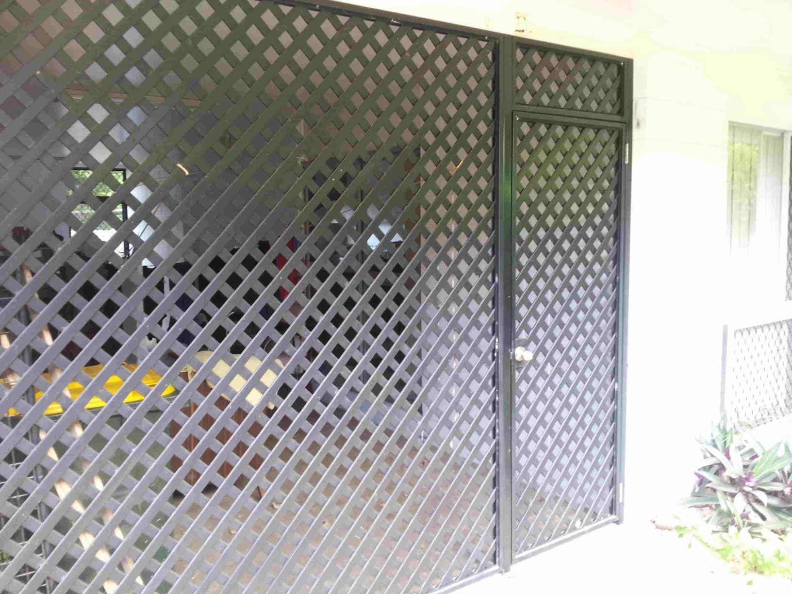 A Black Lattice Fence with A Door in A Garage — A & B Lattice World & Patios in Bungalow, QLD