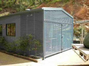A Shed with A Fence and Shutters on The Side of It — A & B Lattice World & Patios in Bungalow, QLD