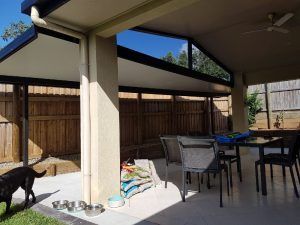 A Dog Is Standing on A Patio Next to A Table and Chairs — A & B Lattice World & Patios in Bungalow, QLD