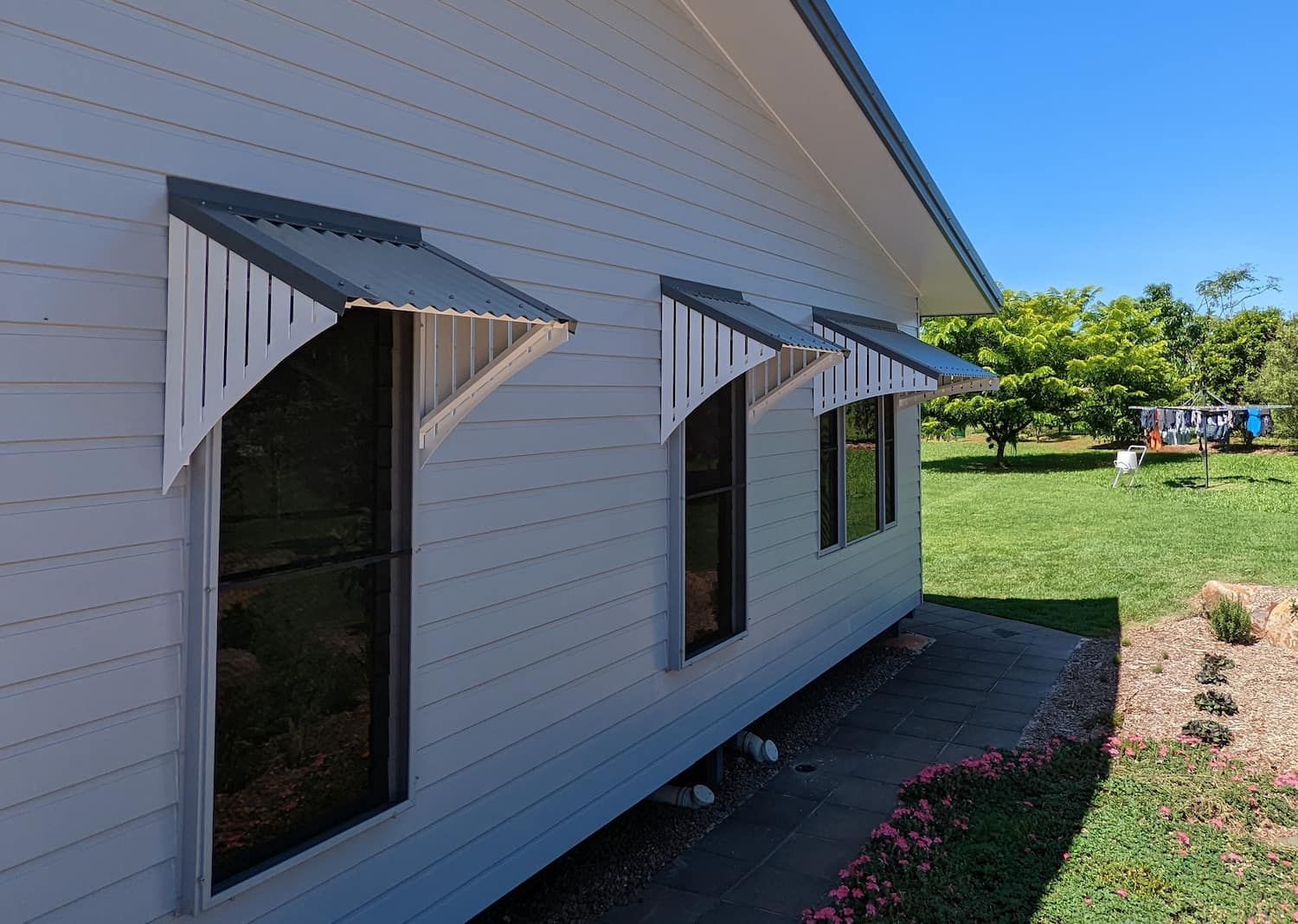 Two Windows on the Side of a House With Awnings on Them — A & B Lattice World & Patios In Tablelands, QLD