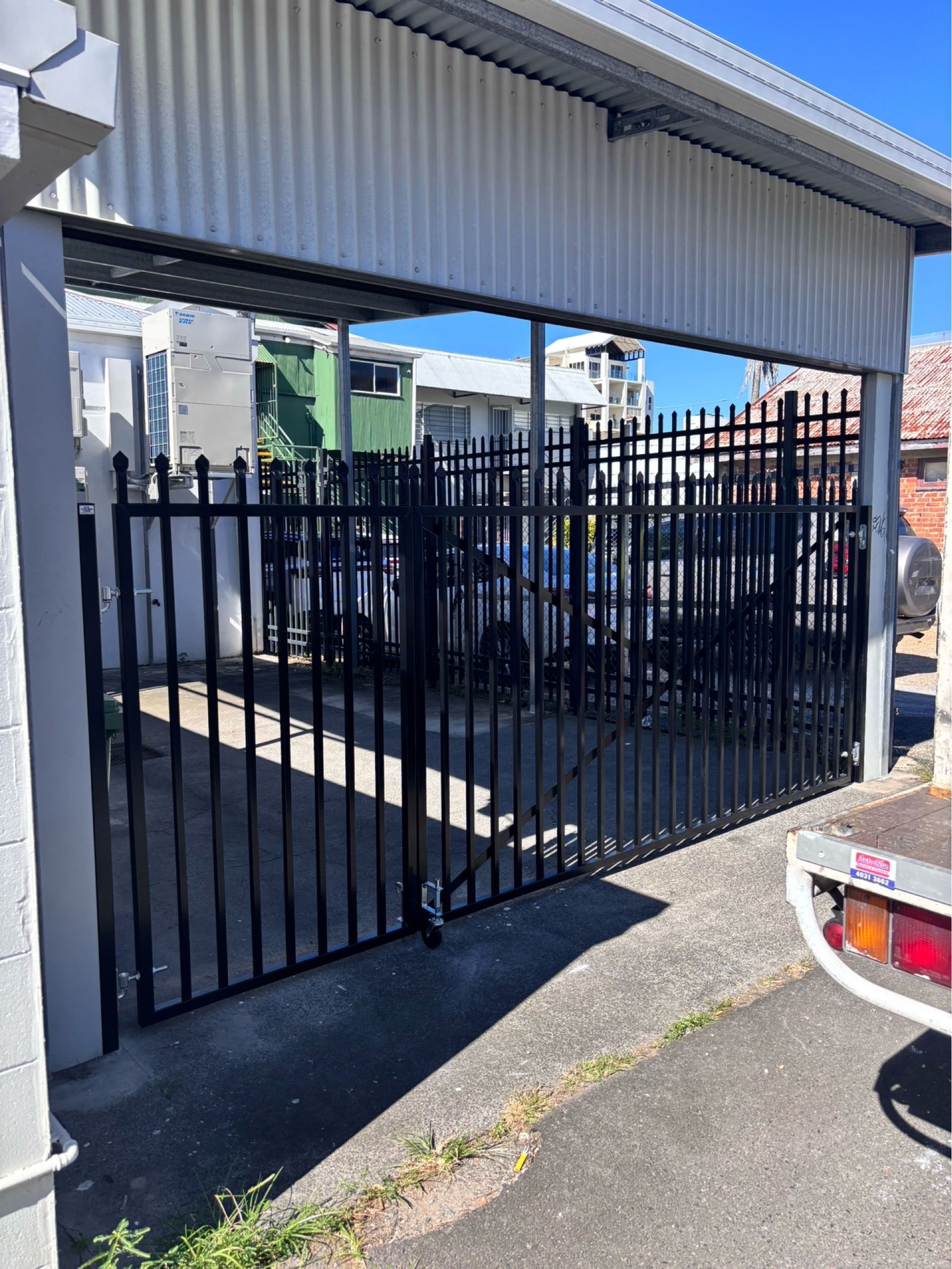 Metal Gated Driveway Beside a Modern House — A & B Lattice World & Patios in Bungalow, QLD