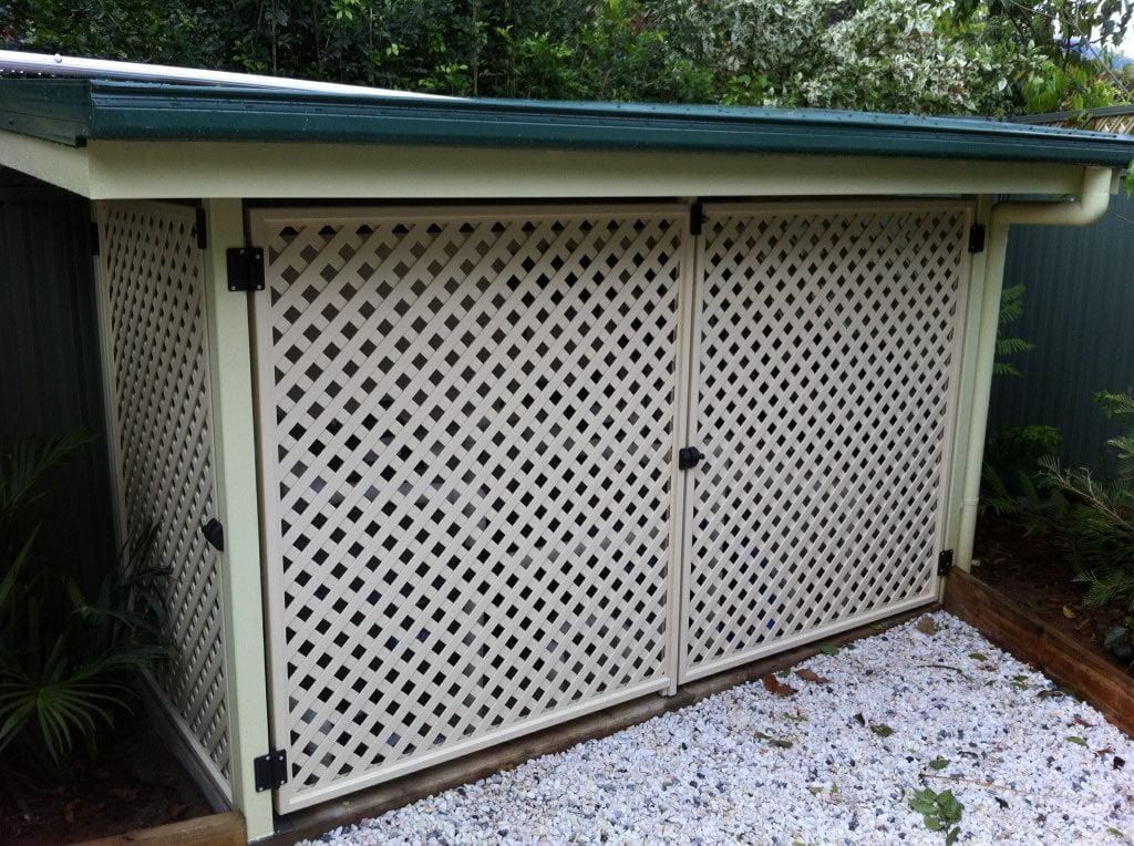 A White Shed with A Green Roof Is Sitting on Top of A Pile of Gravel — A & B Lattice World & Patios in Bungalow, QLD
