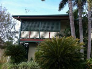 A House with A Balcony and Palm Trees in Front of It — A & B Lattice World & Patios in Bungalow, QLD