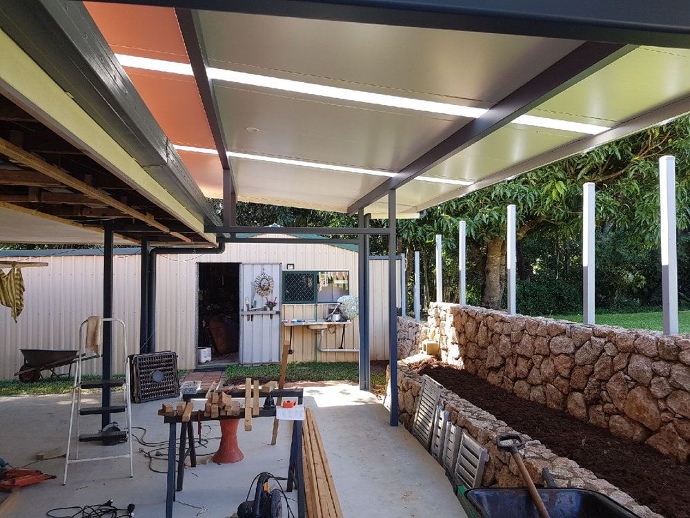 A Patio with A Covered Area and A Stone Wall — A & B Lattice World & Patios in Northern Beaches, QLD