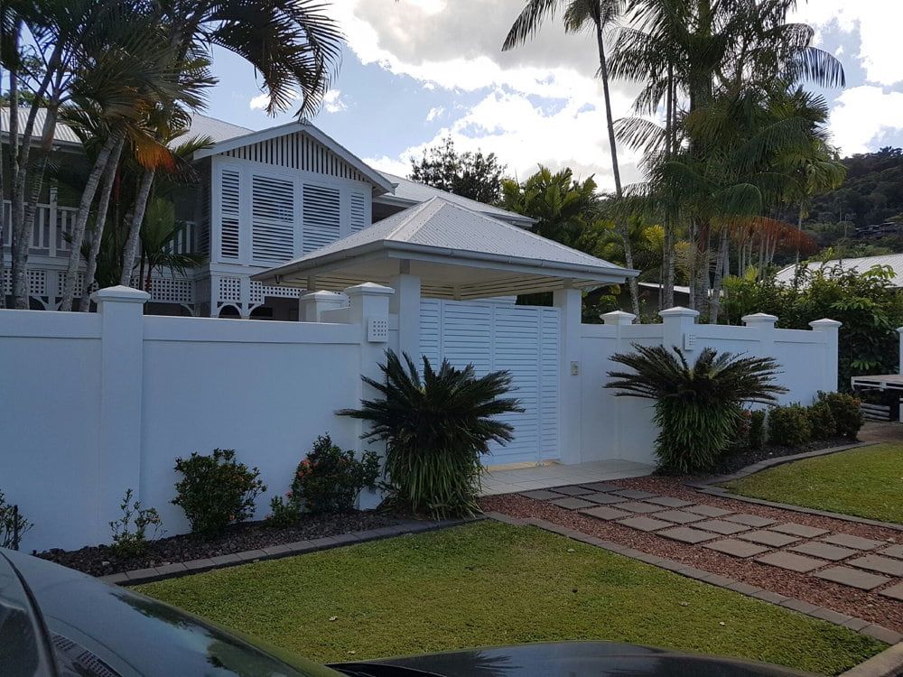 A Black Car Is Parked in Front of A White House — A & B Lattice World & Patios in Bungalow, QLD