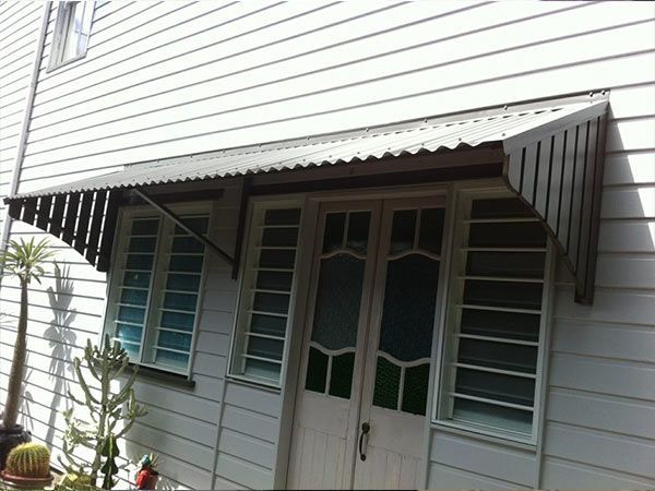 A White House with A Black Awning Over the Door — A & B Lattice World & Patios in Bungalow, QLD
