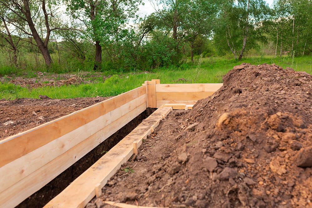 a pile of dirt sitting next to a wooden fence