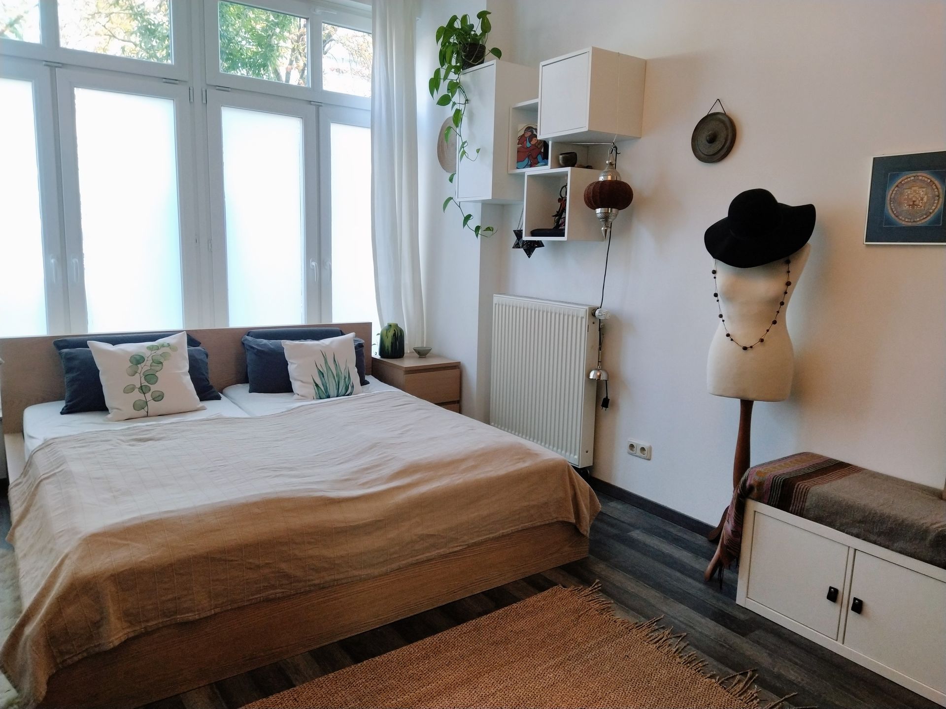A bedroom with a large bed and a mannequin hanging on the wall of our vacation renal in Berlin .