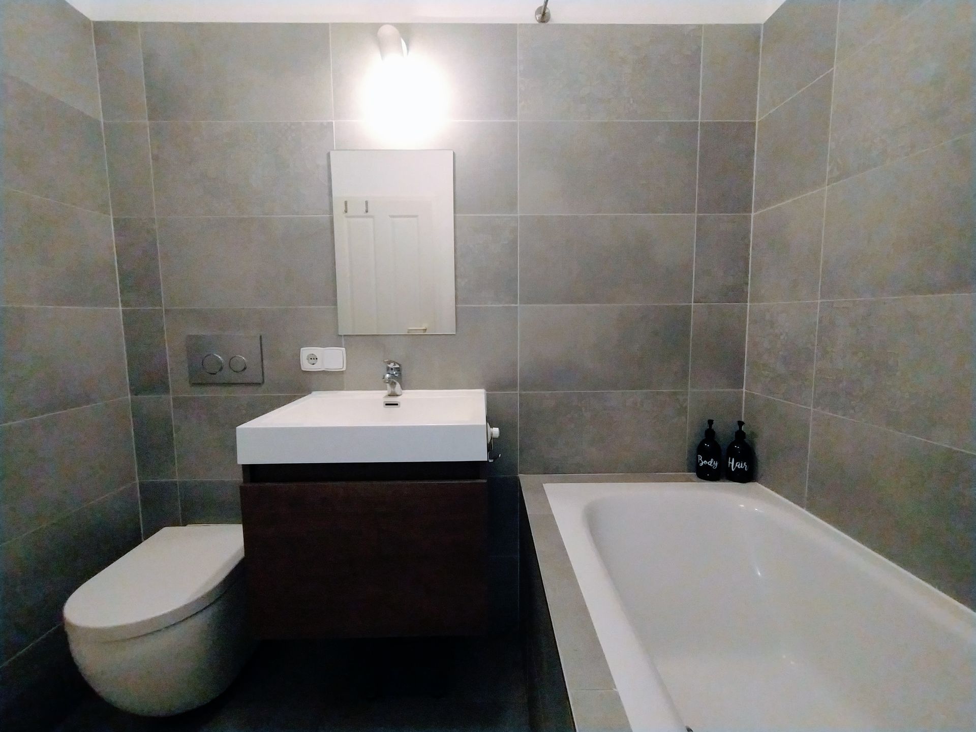 A bathroom with a toilet , sink , and bathtub in our vacation renal in Berlin