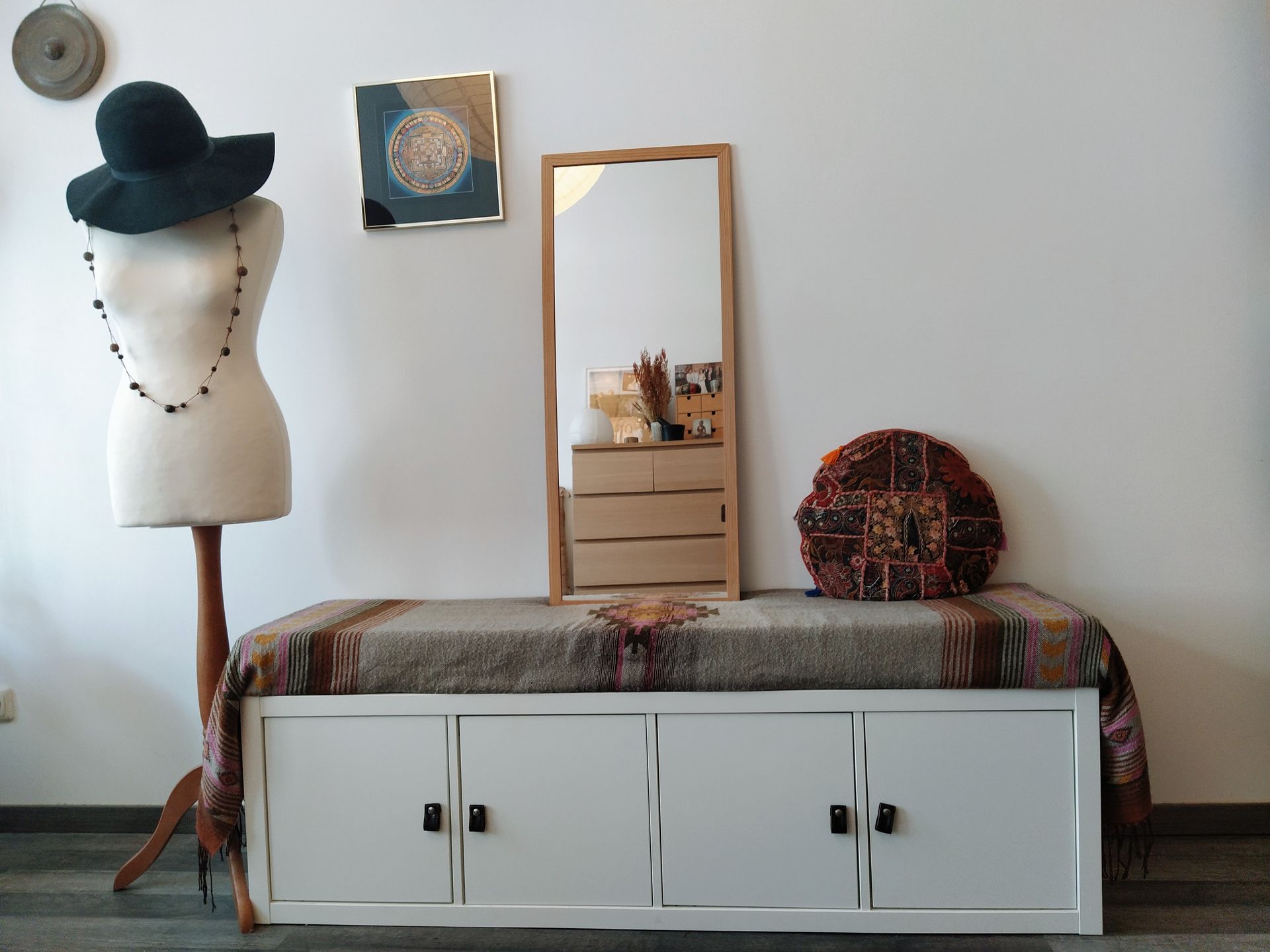 A mannequin is standing next to a bench with a hat on it in our vacation renal in Berlin.