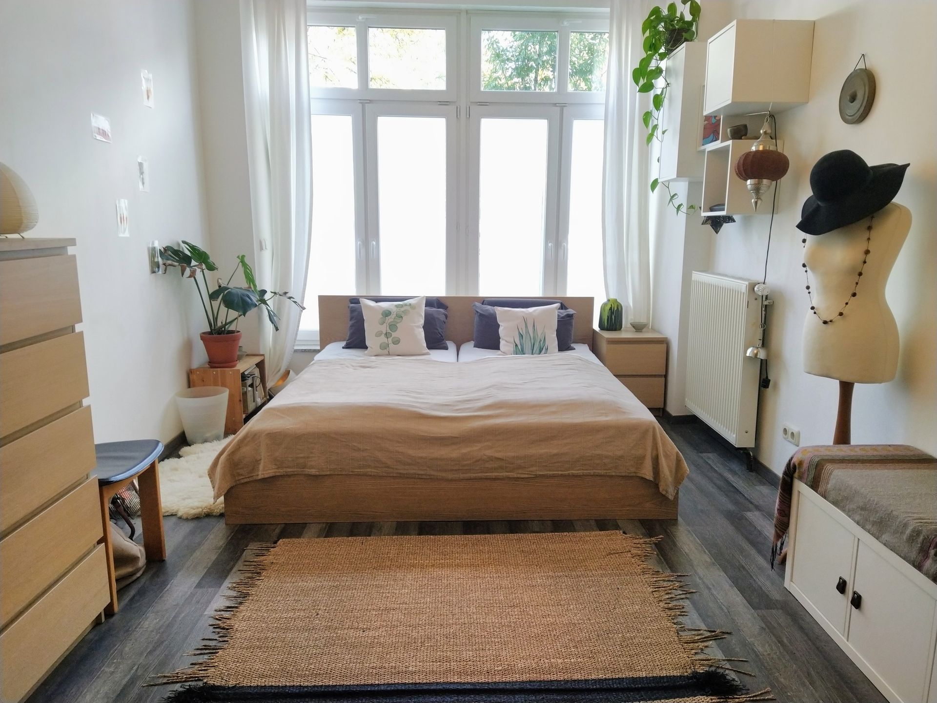A bedroom with a large bed and a rug on the floor