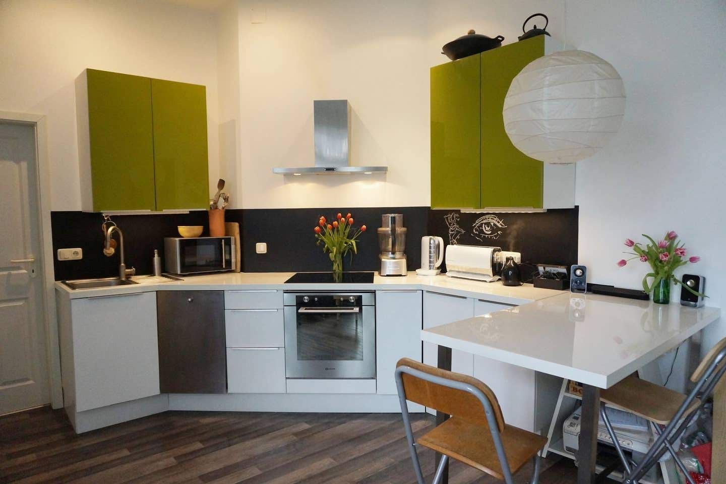 A kitchen of our holiday renal in Berlin with green cabinets and white counter tops