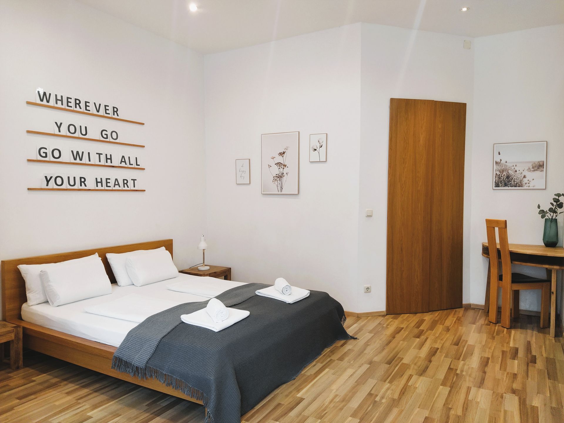 Schlafzimmer mit einem Schild auf dem steht: „Wohin du auch gehst, geh mit ganzem Herzen.“ in unserer Unterkunft in Berlin