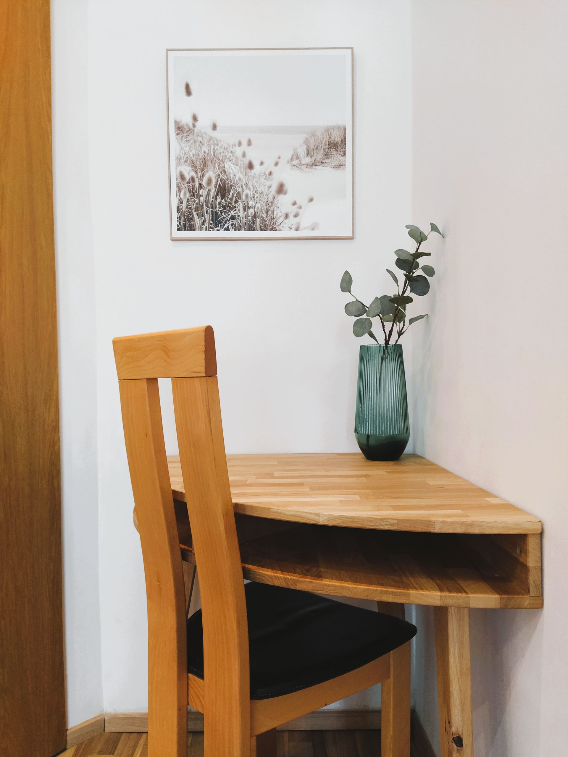 Unsere Ferienwohnung mit privatem Eingang für 3 Personen hat ein Holzschreibtisch mit einem Bild an der Wand darüber.