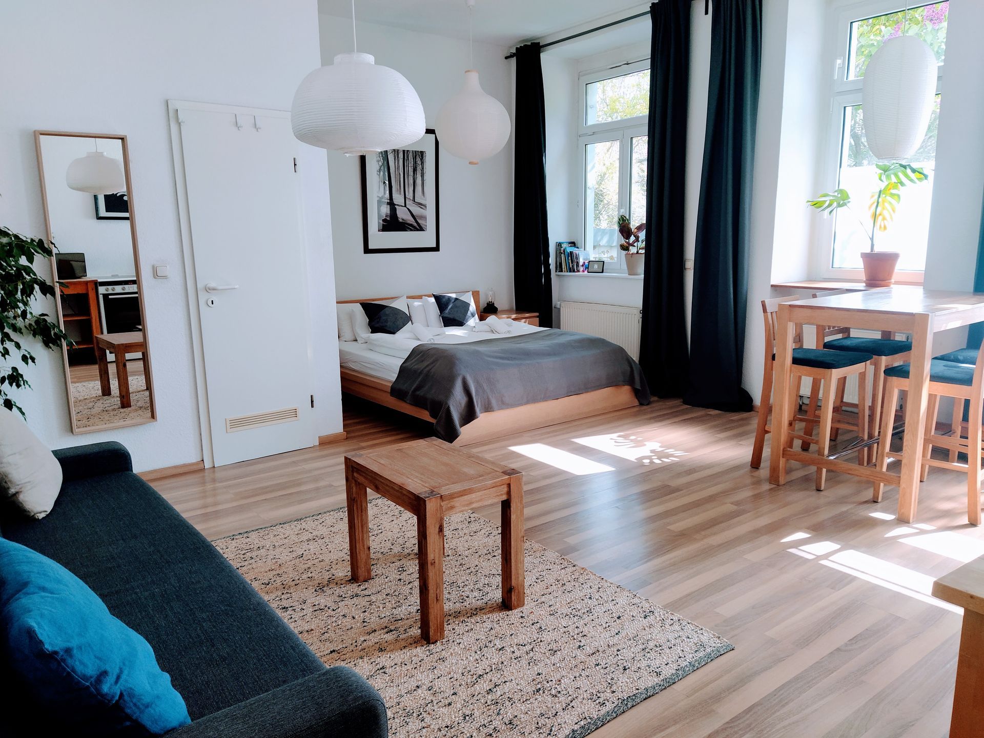 A living room in our holiday rental in Berlin with a couch , table , chairs and a bed.