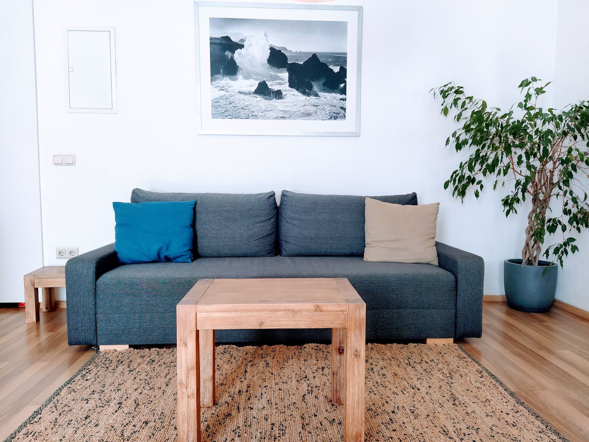 A living room in our holiday rental in Berlin with a couch , table , and picture on the wall.