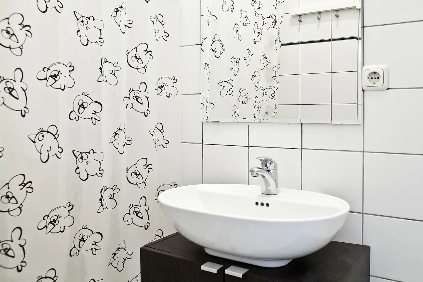 A bathroom with a sink and a shower curtain in our holiday apartment in Berlin